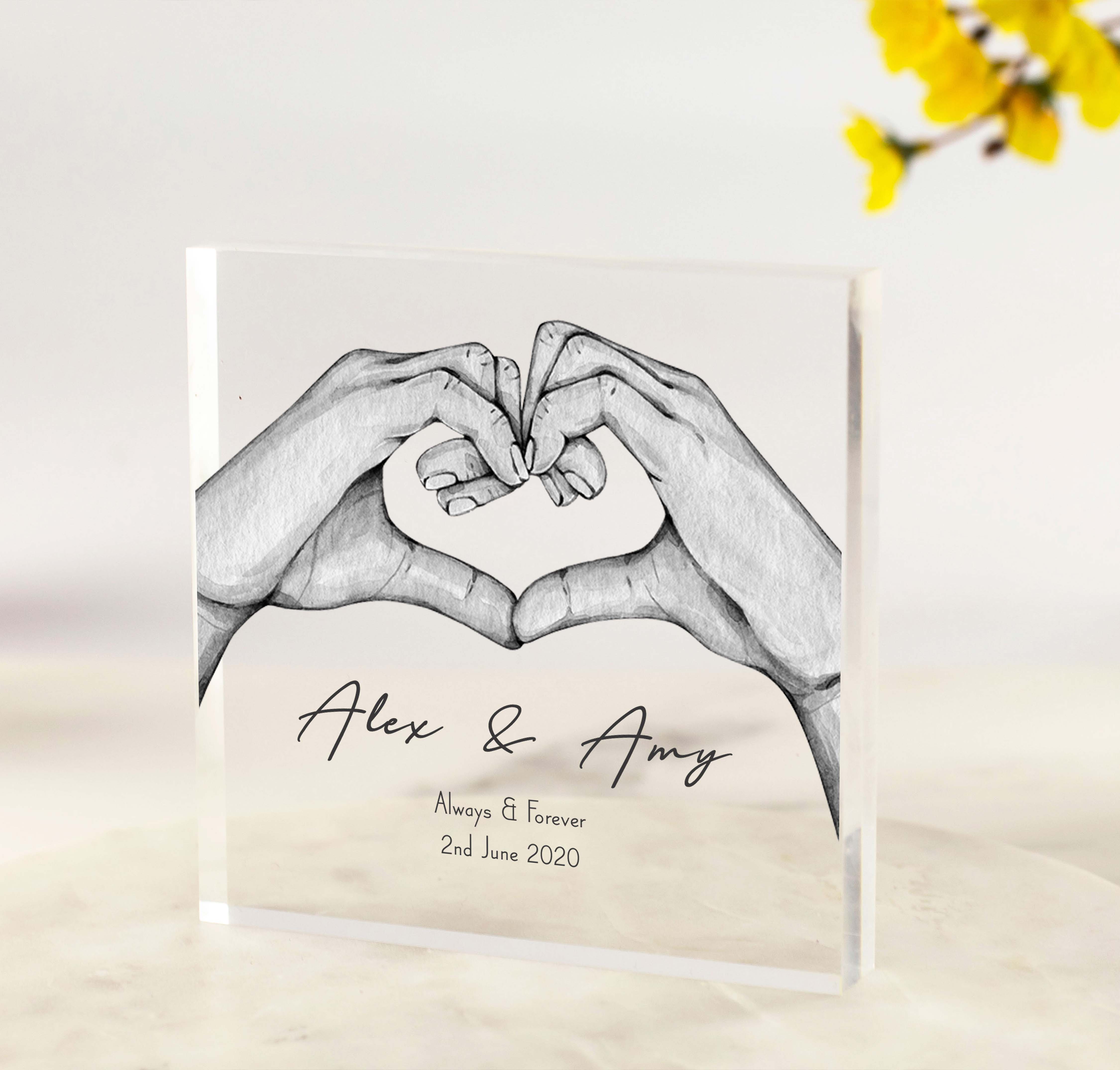 Personalised acrylic block featuring two hands forming a heart, with custom names, date, and wording like “Always & Forever” printed on clear acrylic.