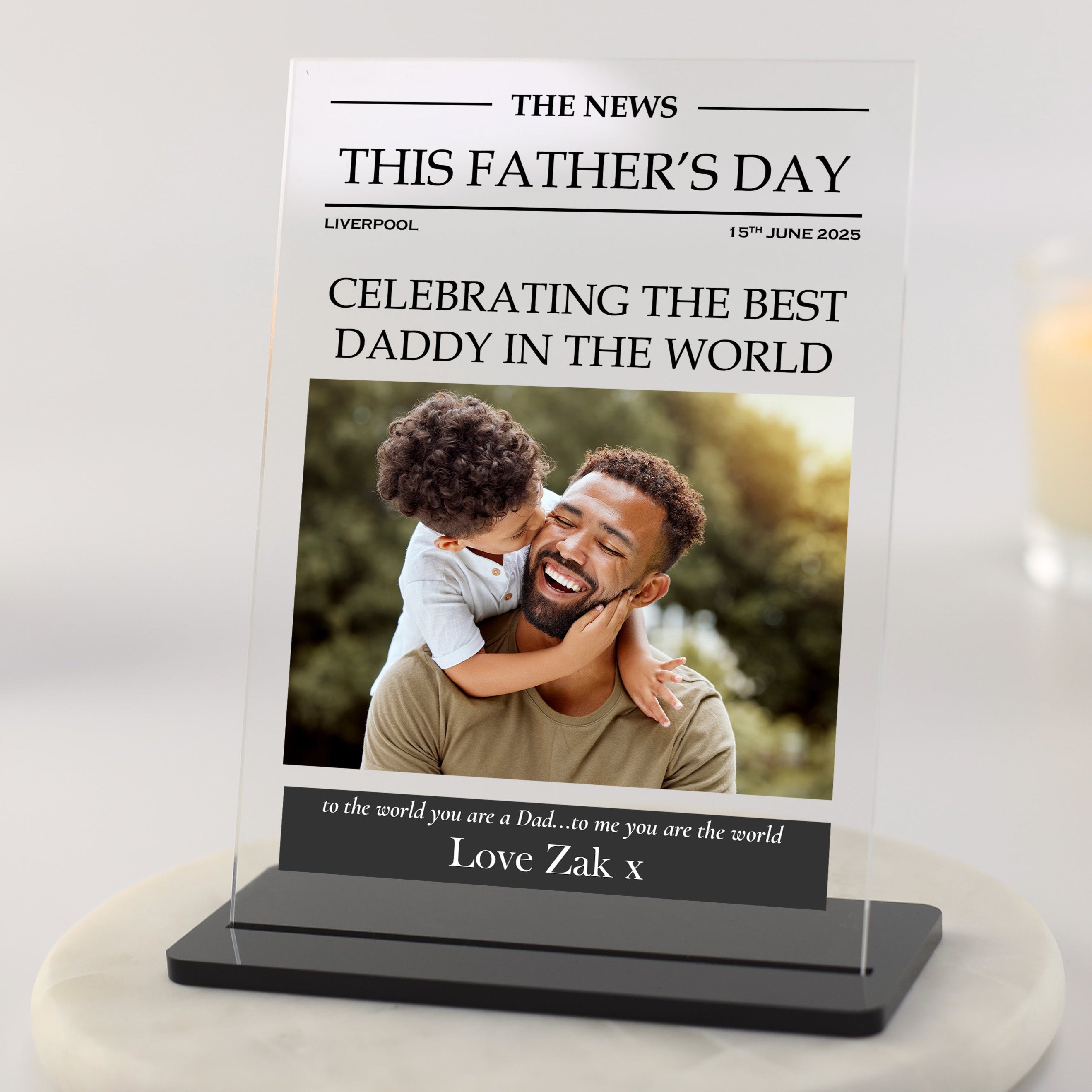 Personalised Father's Day newspaper style photo plaque with headline, dad and child photo, and custom message printed on clear acrylic with black base.