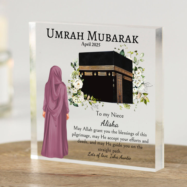 Personalised Umrah Mubarak acrylic block gift featuring a young girl in a mauve hijab standing before an illustration of the Kaaba with floral accents. Includes custom name, relationship (to my niece), date, and dua message. Ideal Islamic gift for Hajj or Umrah return.