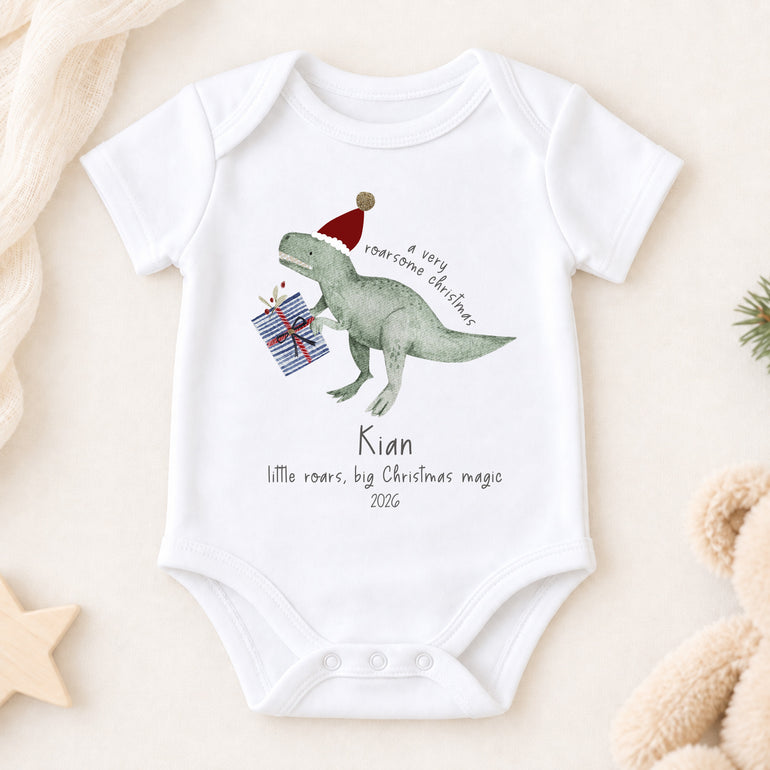 Personalised dinosaur Christmas short-sleeve baby vest with child’s name, year and festive dinosaur illustration