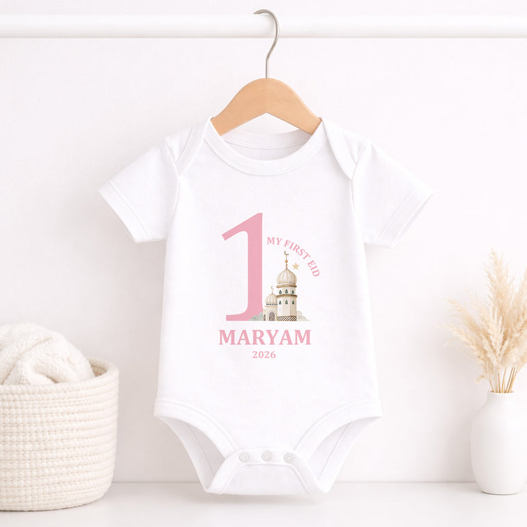 White baby onesie with pink text on a hanger against a white background