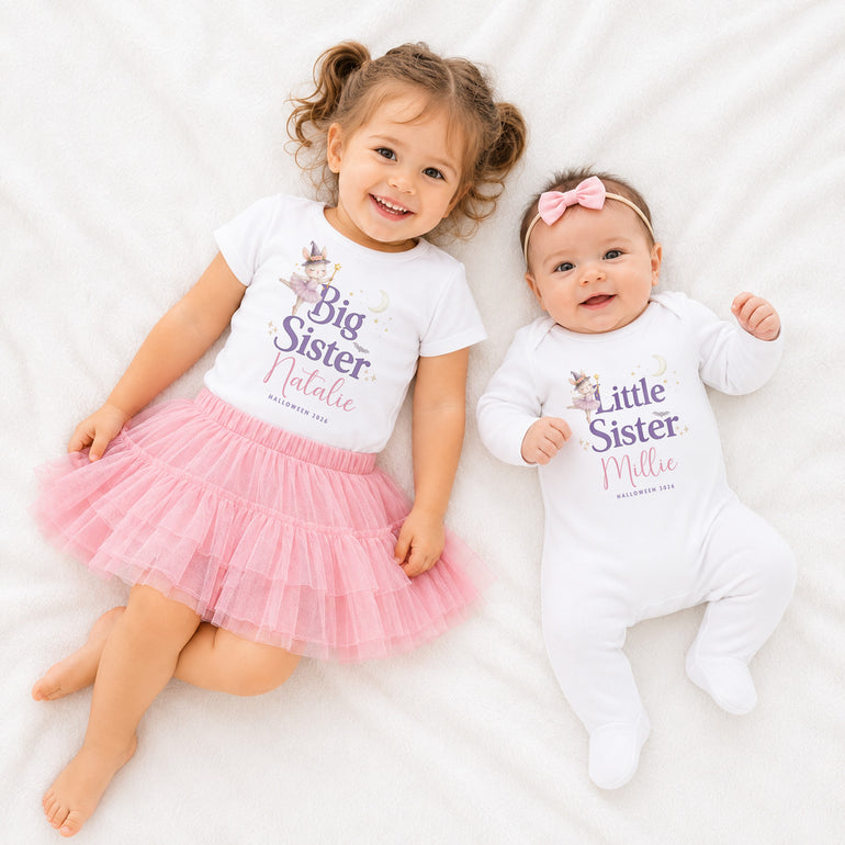 Two sisters wearing personalised Big Sister and Little Sister Halloween clothing, including a white T-shirt and baby grow with their names.
