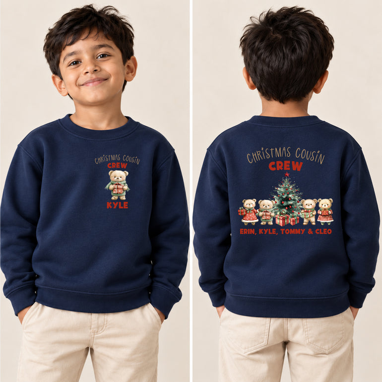 Boy in a navy Christmas Cousin Crew jumper, front with one bear and the name Kyle, back with four bears and all the cousins' names