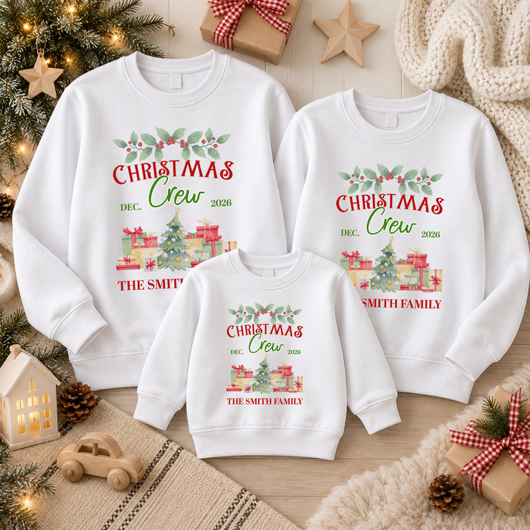 Family of three in white Christmas Crew jumpers with a watercolour Christmas tree and presents, Dec 2026 and The Smith Family