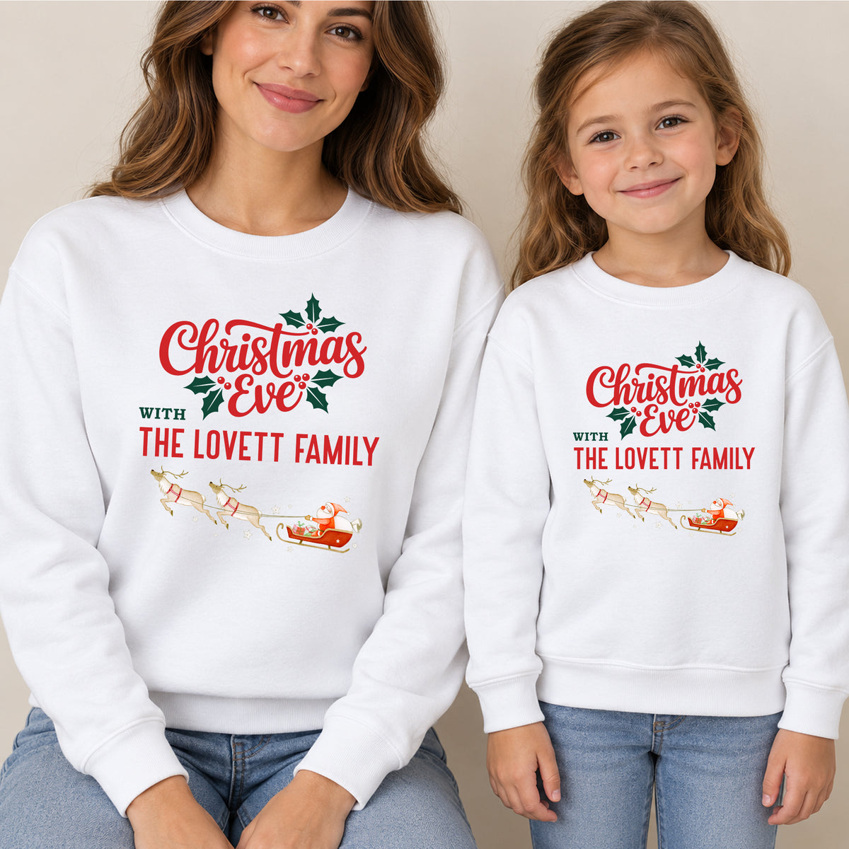 Mum and daughter in matching white Christmas Eve family jumpers reading Christmas Eve with The Lovett Family, with Santa's sleigh and reindeer