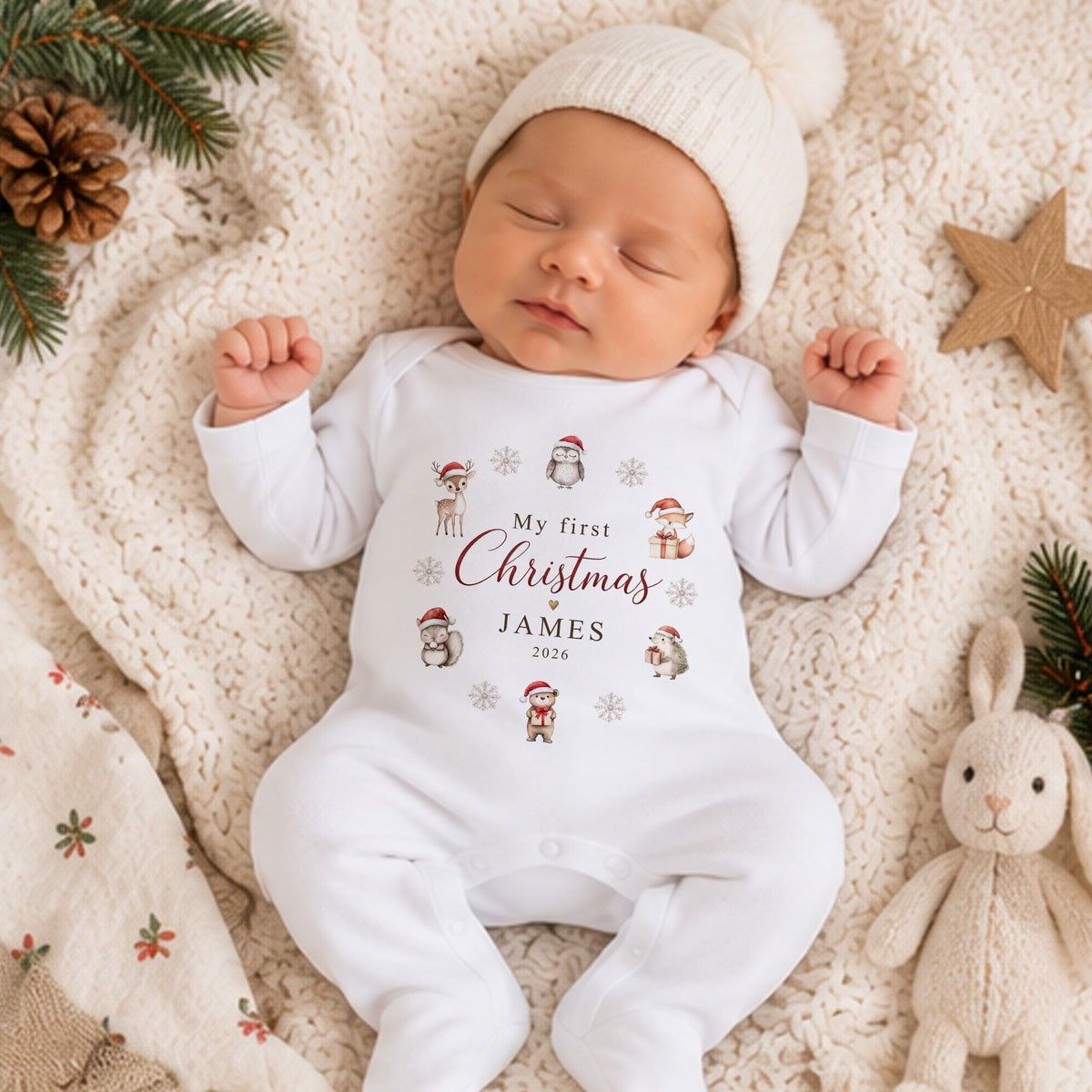 Newborn baby wearing personalised My First Christmas baby grow with festive woodland animals, name James and custom Christmas year