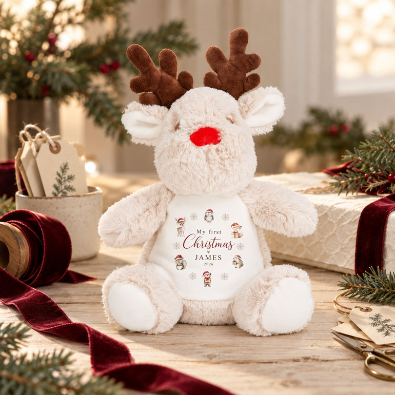 Personalised reindeer first Christmas soft toy with woodland animal design, example name James and year 2026 in a festive Christmas setting
