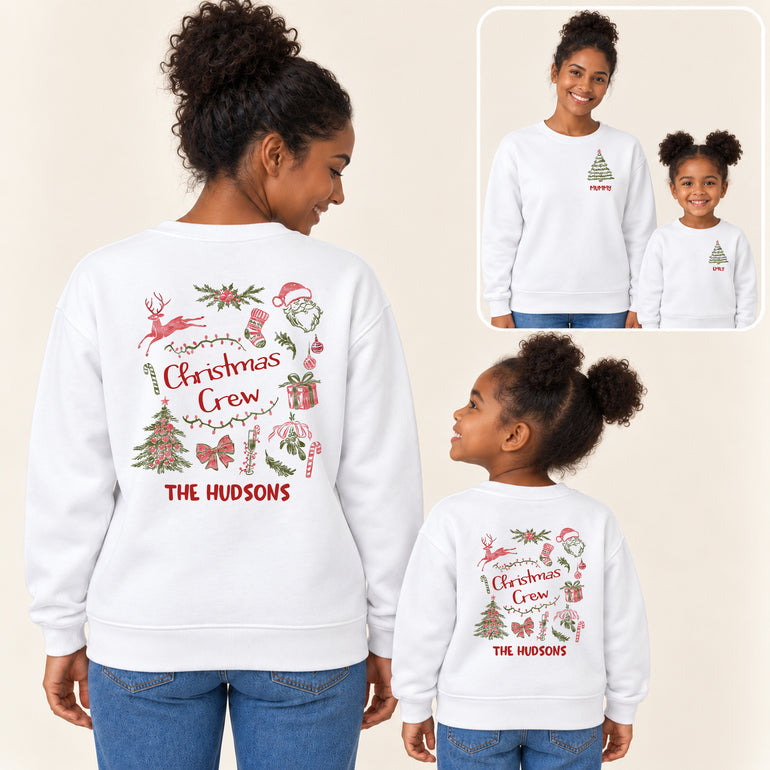 Mum and daughter in white Christmas family jumpers, the back showing a Christmas Crew design with Santa, reindeer and The Hudsons, the front a small tree with their names