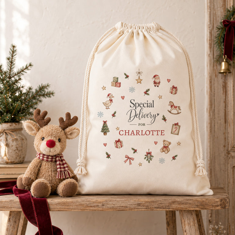 Personalised Christmas sack with name and miniature festive motifs displayed beside a Christmas reindeer soft toy.