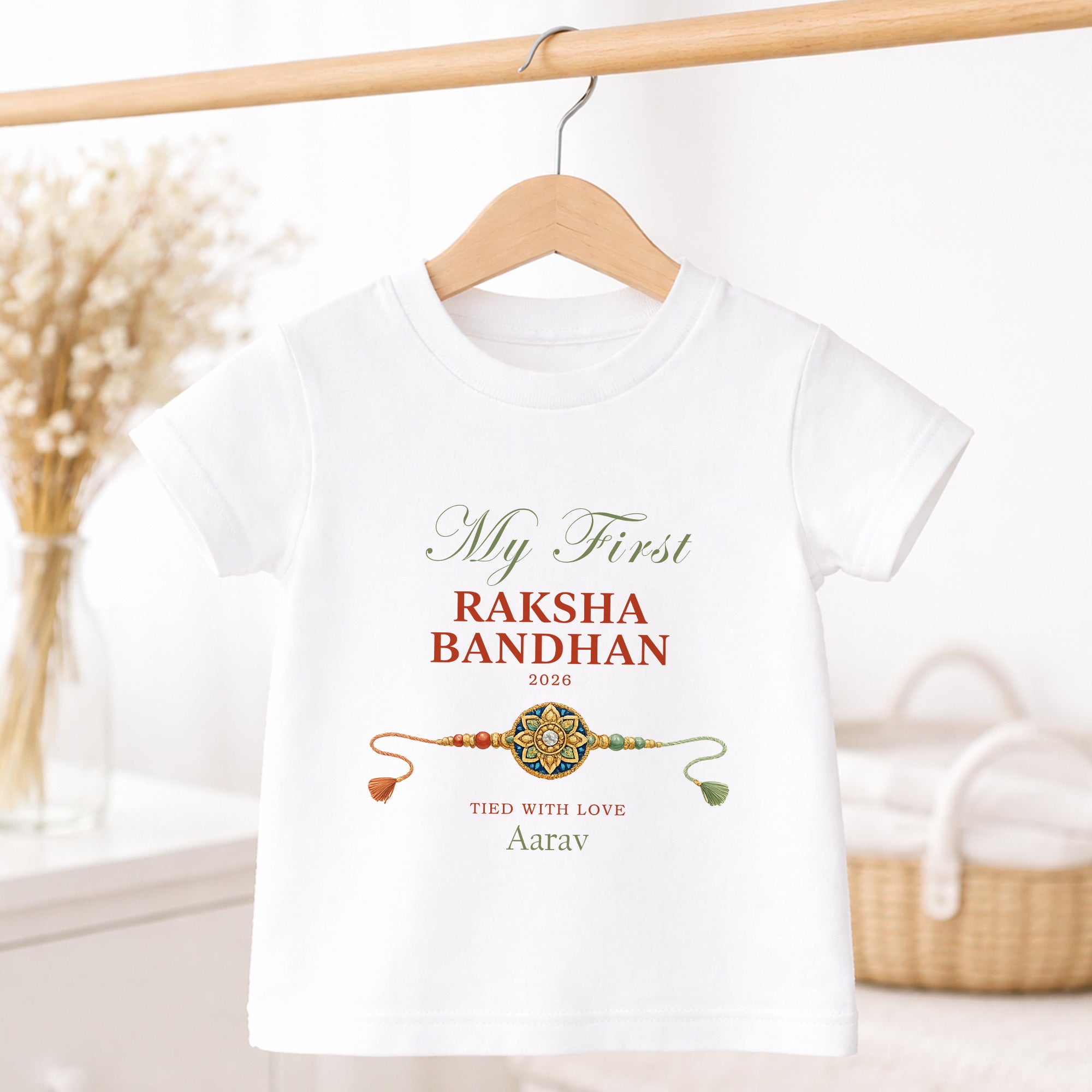 White children’s T-shirt personalised with My First Raksha Bandhan, Aarav, the year 2026 and a traditional rakhi.