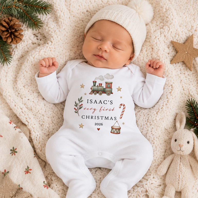 Baby wearing personalised Vintage Train Very First Christmas baby grow with child’s name, year, candy cane and toy drum