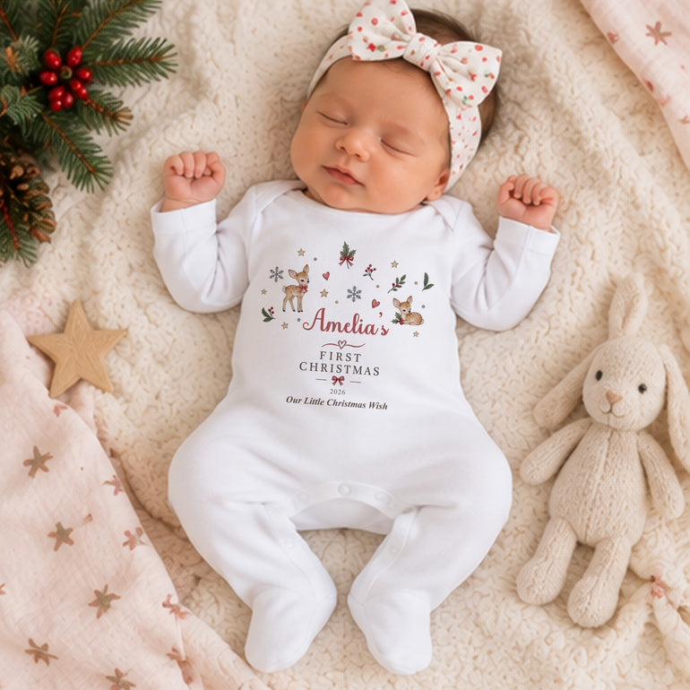 Newborn baby wearing personalised Reindeer First Christmas baby grow with name Amelia, festive motifs and custom Christmas year