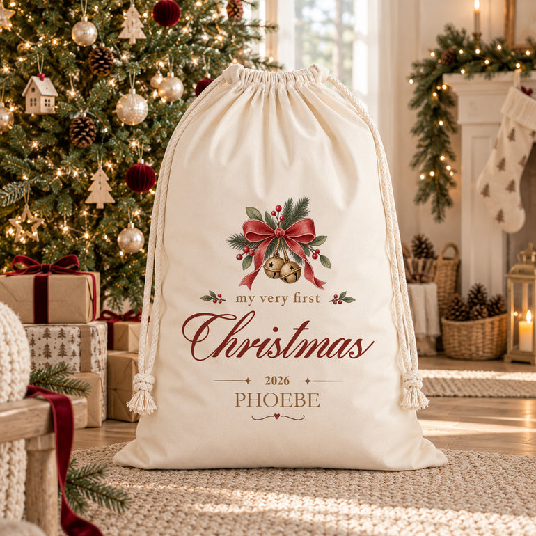 Personalised baby’s First Christmas sack with gold bells, red bow, child’s name Phoebe and chosen Christmas year