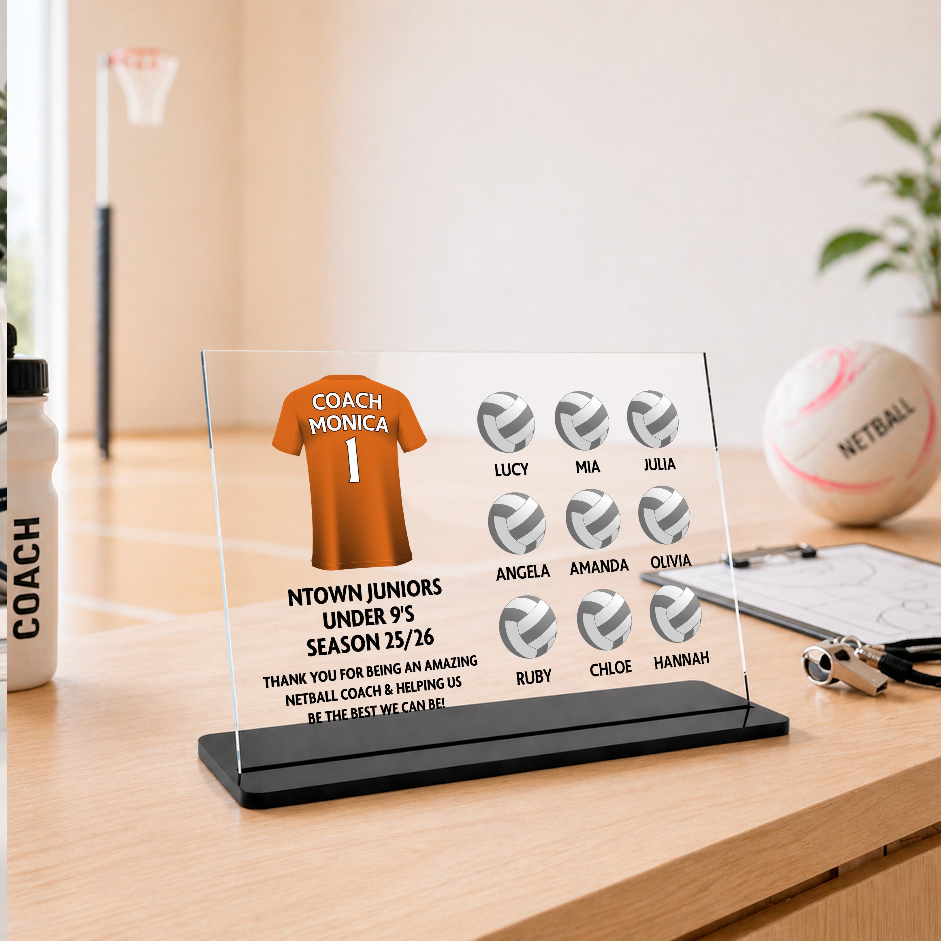 Personalised netball coach thank you acrylic plaque with custom orange coach shirt, team name, season wording, thank you message and player names with netball ball designs.
