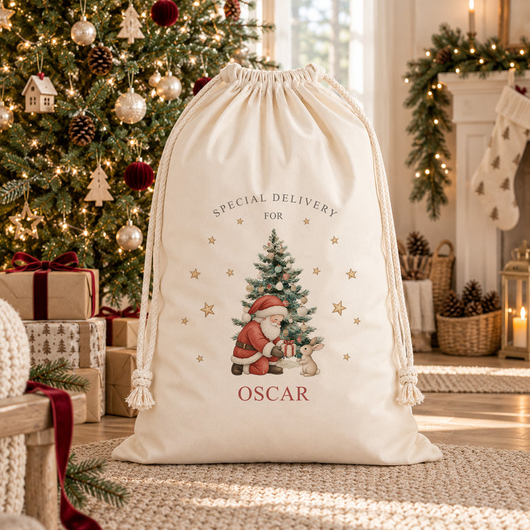 Large personalised Santa sack with Special Delivery For name design featuring Santa giving a present to a bunny beside a Christmas tree.