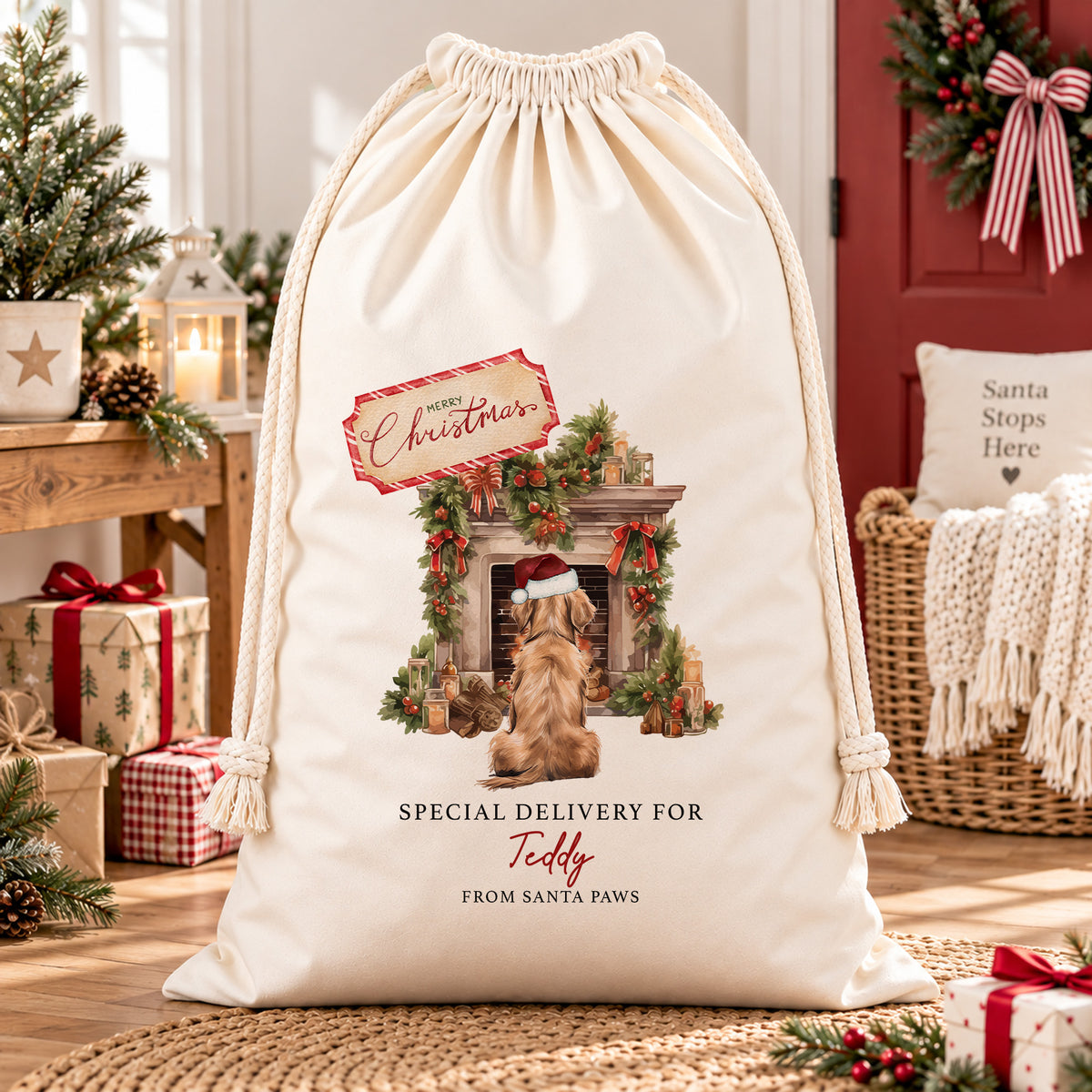Cream personalised pet Christmas sack named Teddy, showing a dog in a Santa hat beside a decorated fireplace, displayed in a festive room.
