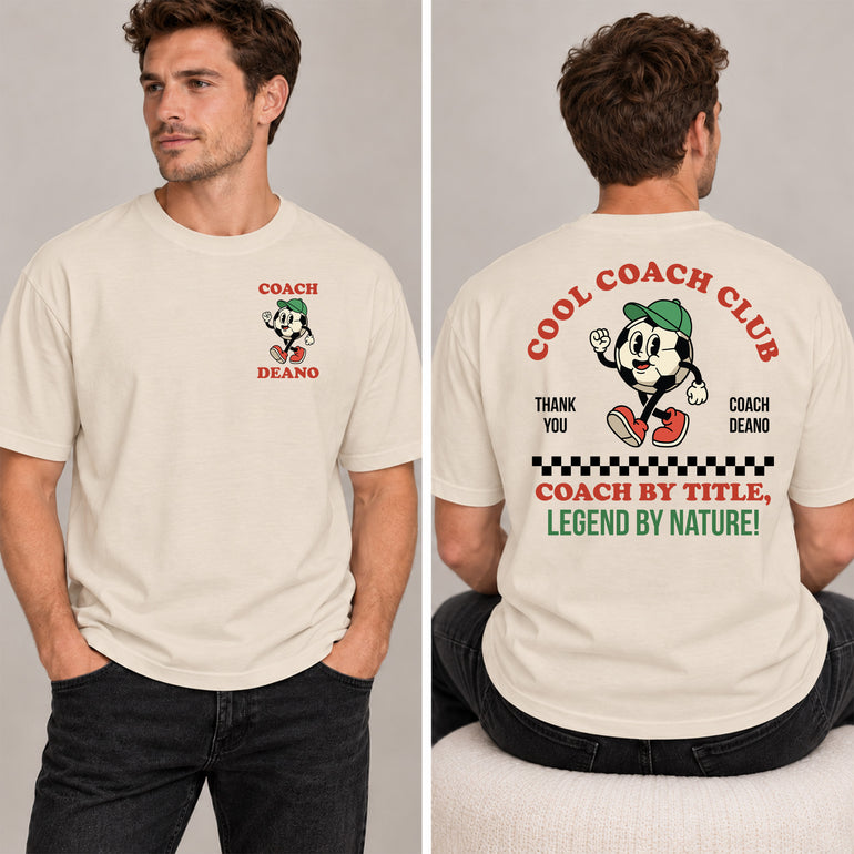 Man in a sand Cool Coach Club football coach gift T-shirt, the back printed with Cool Coach Club, a retro cartoon football character in a green cap, Thank You, Coach Deano and Coach by Title, Legend by Nature, the front with a small Coach Deano badge