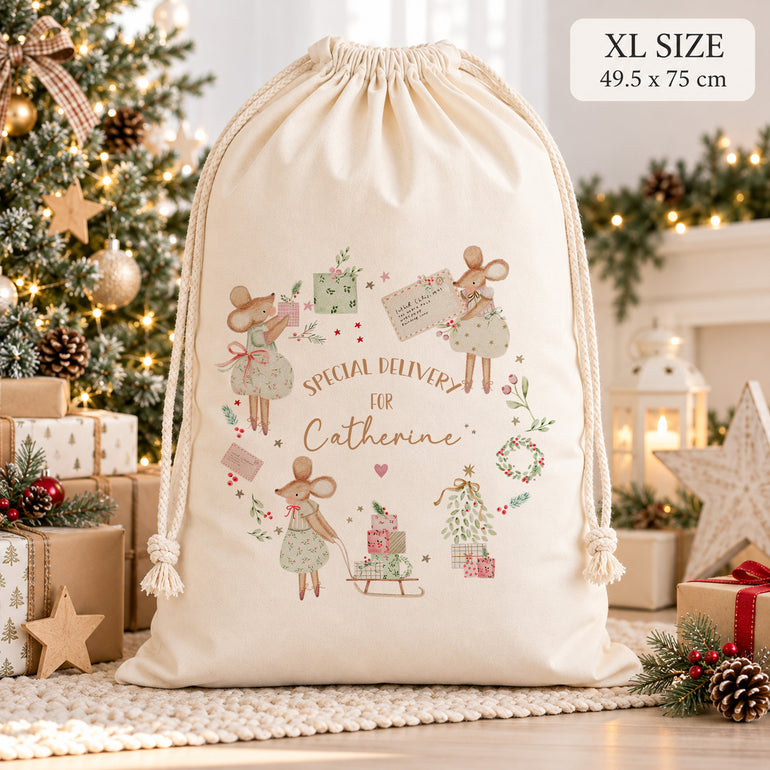 XL personalised Christmas sack with festive mice and the name Catherine, displayed beside a decorated Christmas tree.