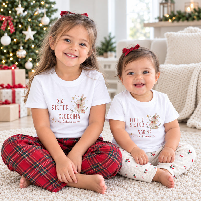 Big Sister and Little Sister wearing personalised matching Christmas shirts with fairy bunny Believes designs and individual names