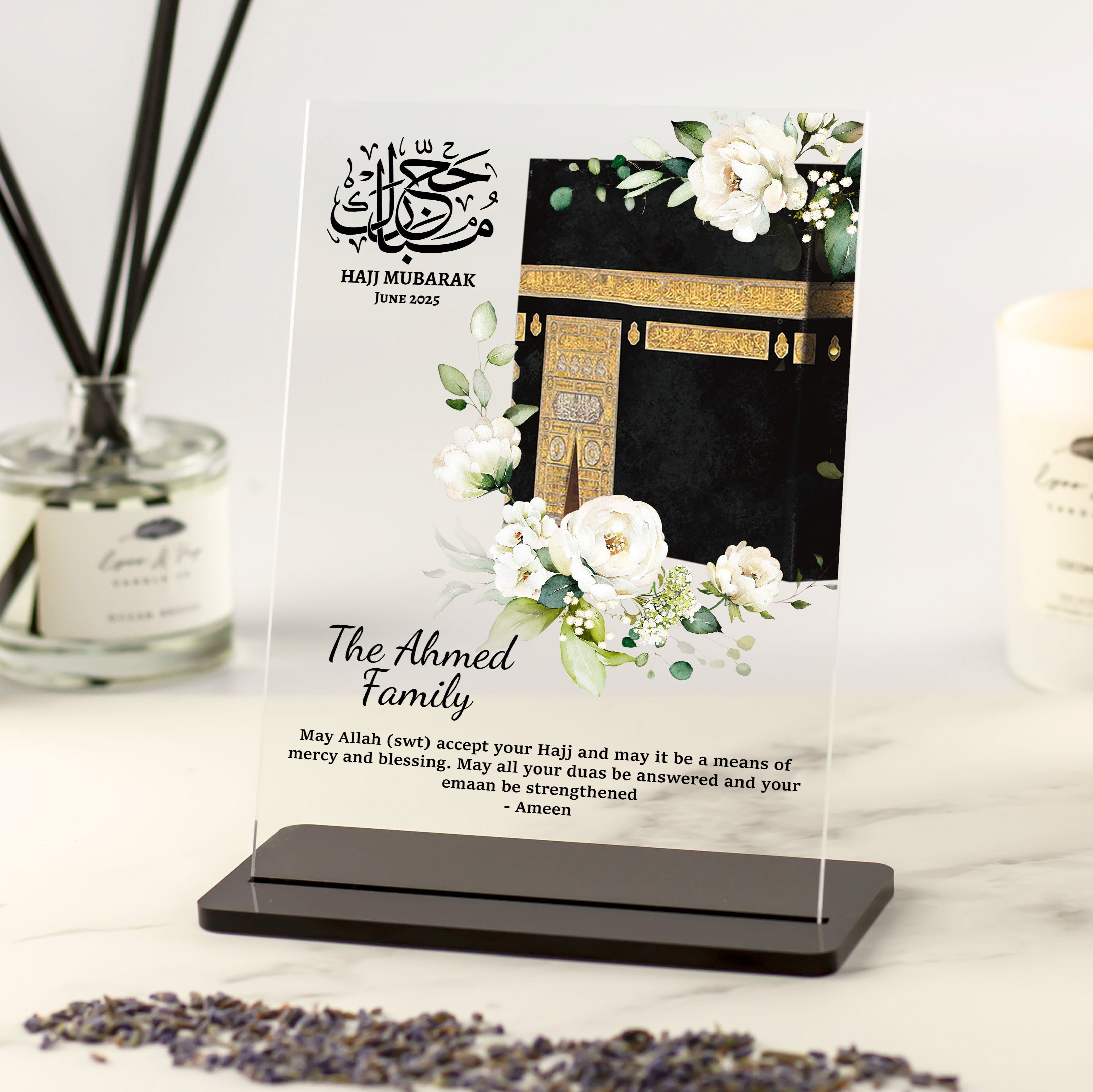Personalised Hajj Mubarak acrylic plaque with Kaaba illustration, white floral accents, and custom family name and dua in elegant black font.