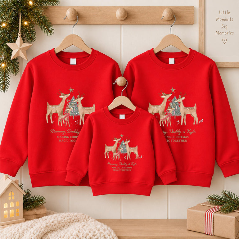 Three red personalised family Christmas jumpers on wooden hangers, two adult and one child, with the reindeer family design and example names