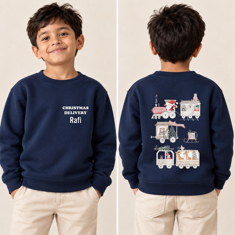 Boy shown front and back in a navy personalised Santa train Christmas jumper, with Christmas Delivery and his name on the front and a Santa train on the back