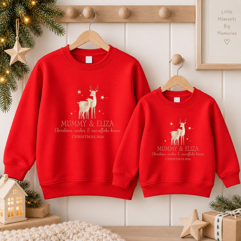 Red personalised mum and daughter Christmas jumpers on wooden hangers, with the reindeer and fawn design, two example names and an example year