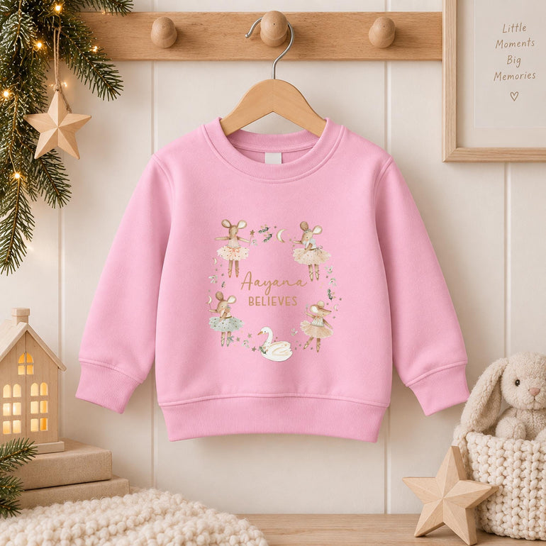 Light pink girls Christmas jumper on a hanger with the ballerina mice wreath design and a name in gold