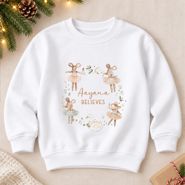 White personalised girls Christmas jumper laid flat, with a wreath of ballerina mice and a white swan around a name in gold script