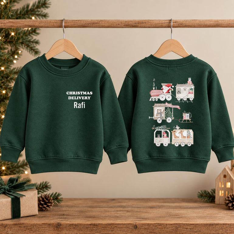 Forest green kids Santa train Christmas jumper shown front and back on wooden hangers, with white lettering on the front and the train illustration on the back
