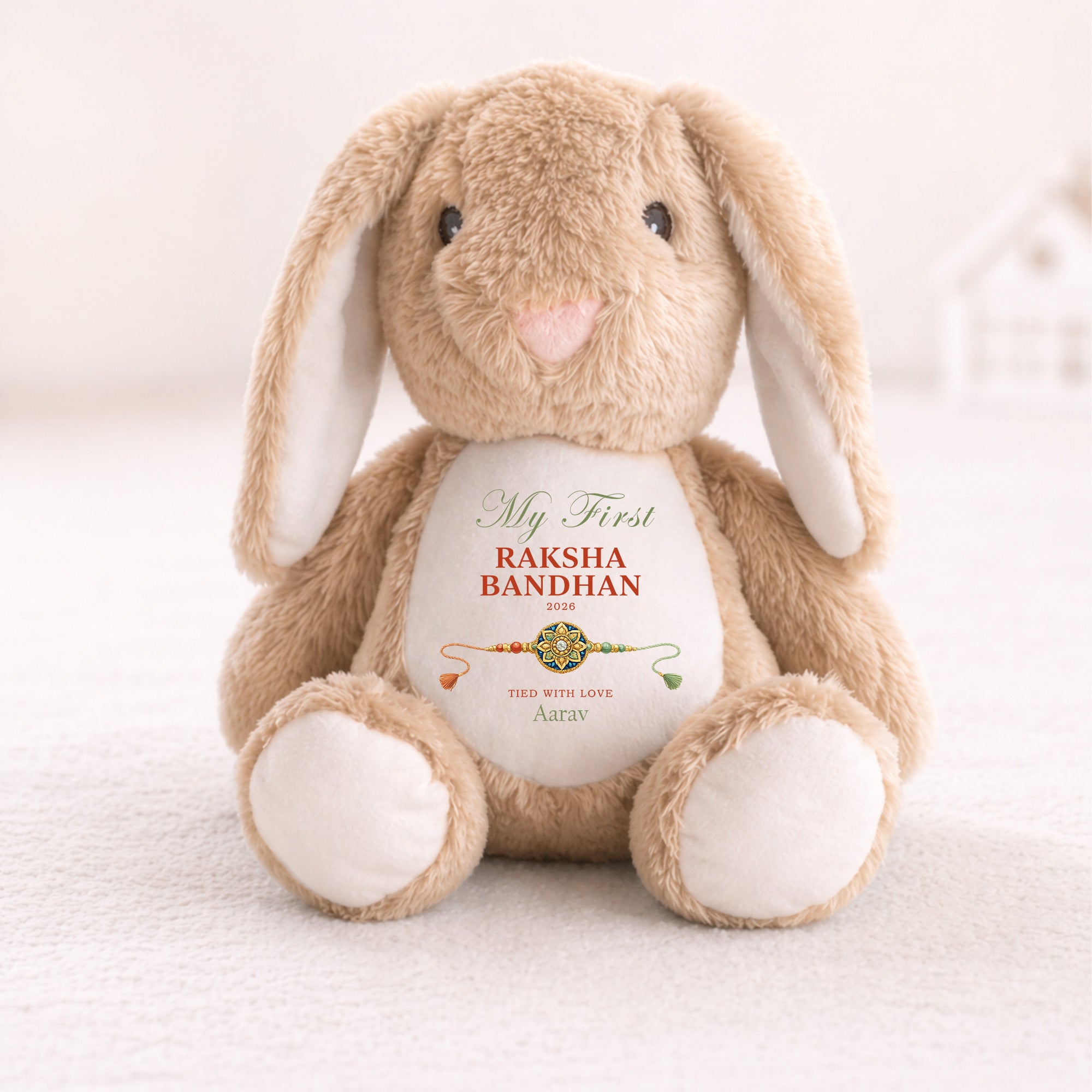 Neutral bunny personalised with My First Raksha Bandhan, the name Aarav, the year 2026 and a traditional rakhi.

