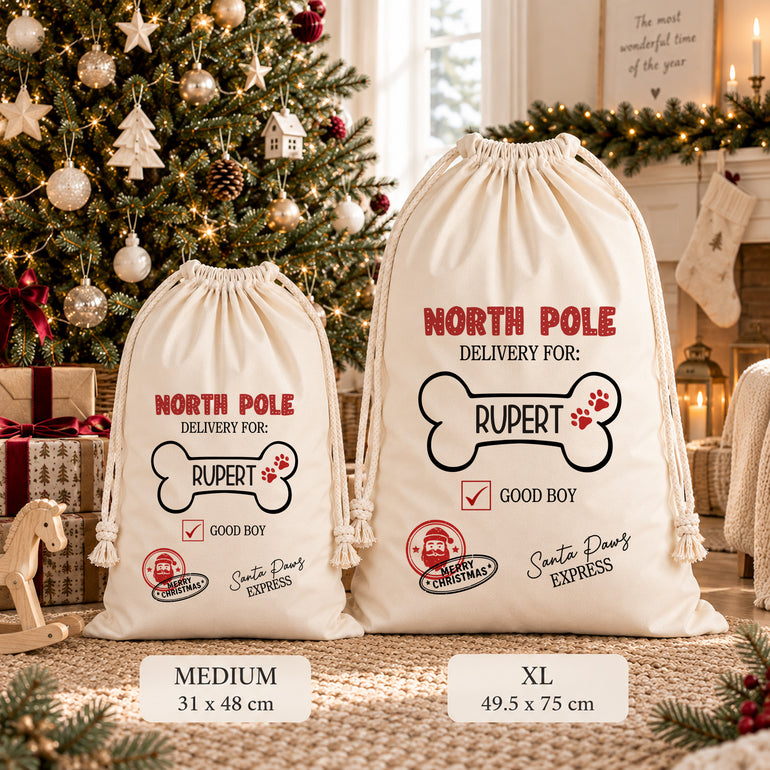 Medium and XL North Pole dog Christmas sacks side by side, showing the bone-shaped name design and measurements beneath each size.