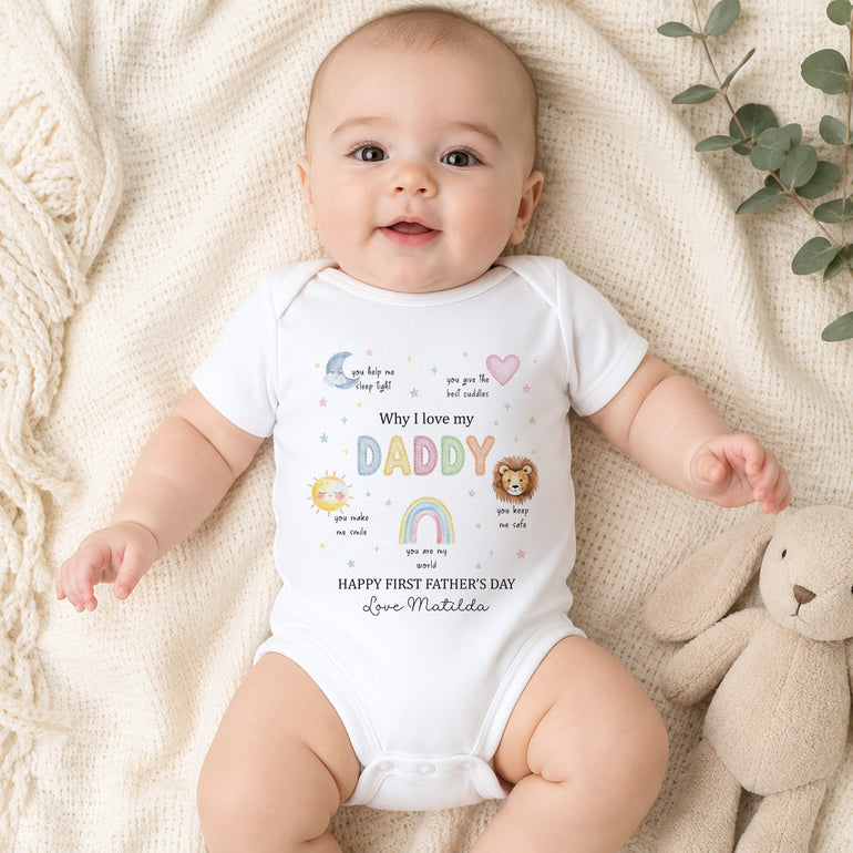 Baby wearing personalised Why I Love My Daddy Father’s Day vest with pastel motifs and Happy First Father’s Day wording.