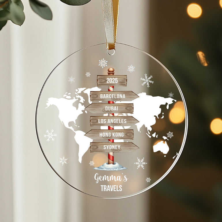 Decorative Christmas ornament with world map and travel destinations on a blurred light background