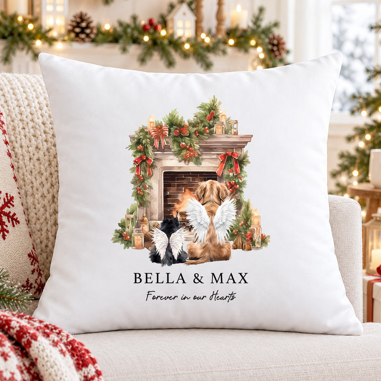 Personalised Christmas pet memorial cushion with two angel wing pets beside a festive fireplace and Forever in our Hearts wording